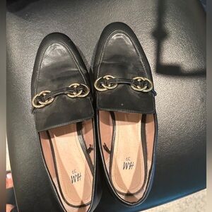 Black loafers/flats with gold buckle.